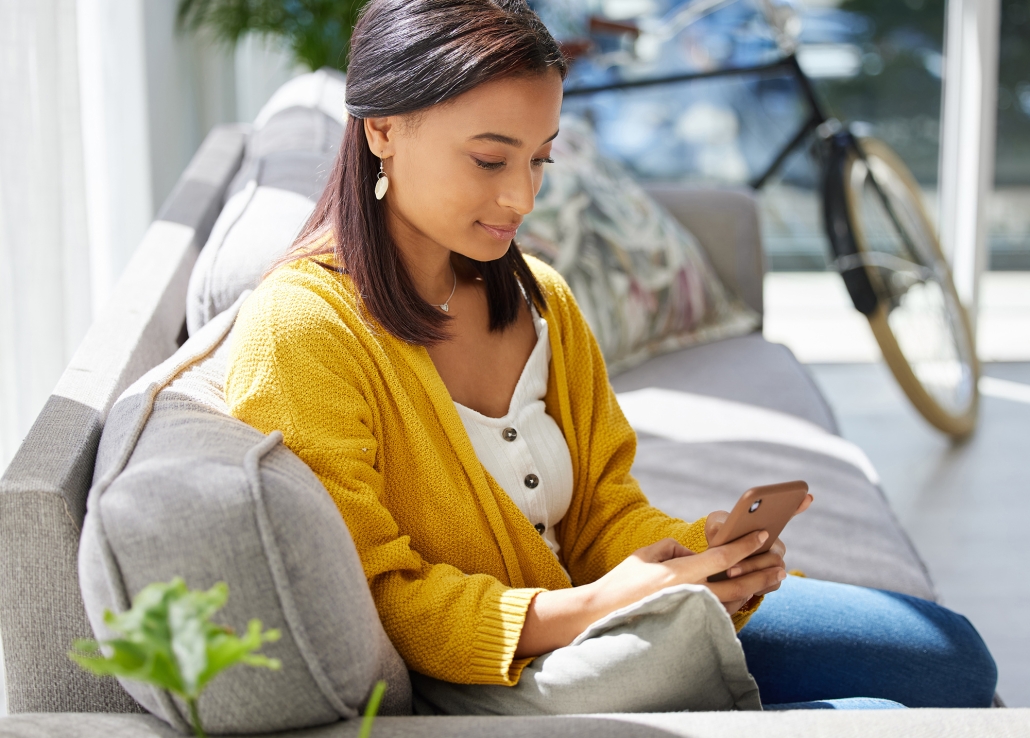 Ive got entertainment right here. Shot of a young woman using a phone at home